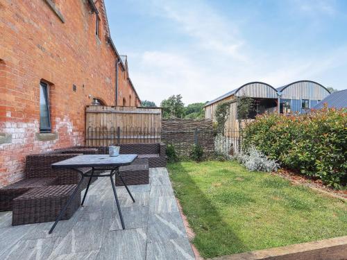 a patio with a table and benches in a yard at Plough Share in Gloucester