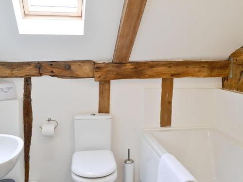 a bathroom with a white toilet and a sink at Burfields Barn in Botesdale