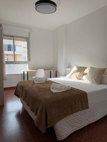 a bedroom with a large bed with two towels on it at Bright & Spacious Apartment in Nerja Centre in Nerja