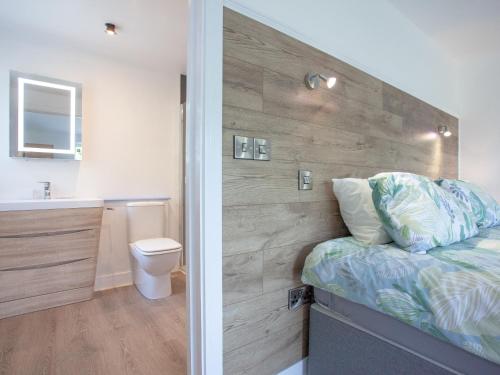 a bathroom with a bed and a toilet and a sink at Kingfisher Lodge - Uk33889 in Cullompton