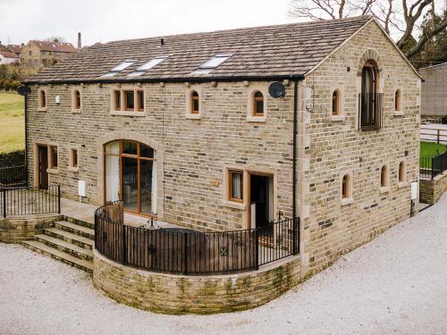 a large brick building with a fence around it at Sycamore Barn - Uk33353 in Buttershaw