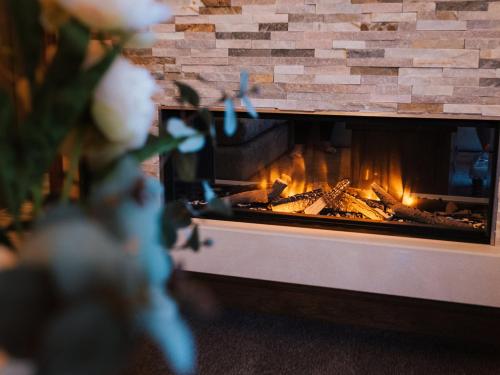 a brick fireplace with a fire in it at Sycamore Barn - Uk33353 in Buttershaw