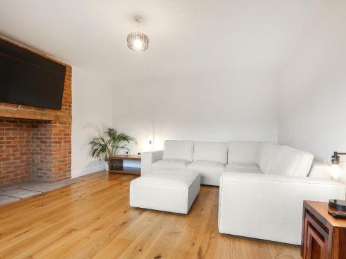 a living room with a white couch and a fireplace at Chancery View in Ross on Wye
