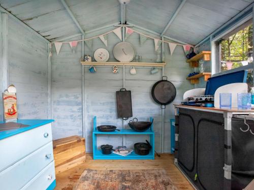 a kitchen with blue shelves and a stove in it at Uk45543-The Threshing Barn in Sticklepath