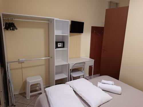 a bedroom with a bed and a desk with towels at HOTEL GIORDANA in Loano