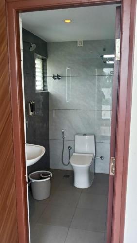 a bathroom with a toilet and a sink at Hotel Amulya Royal Inn in Bangalore