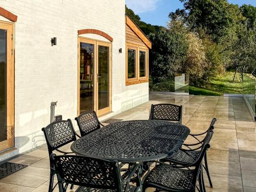 a black table and chairs on a patio at Quabbs Head Cottage in Mathon