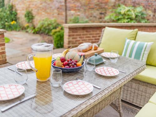 a table with a bowl of fruit and a glass of beer at Bank House Apartment in Newnham