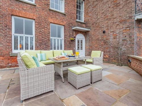 a patio with wicker furniture and a table and chairs at Bank House Apartment in Newnham