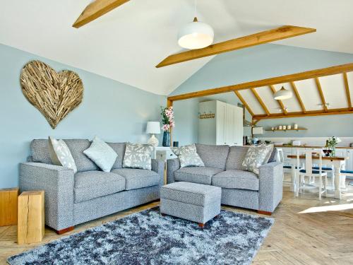a living room with two couches and a table at Woodland View Lodge in Axminster