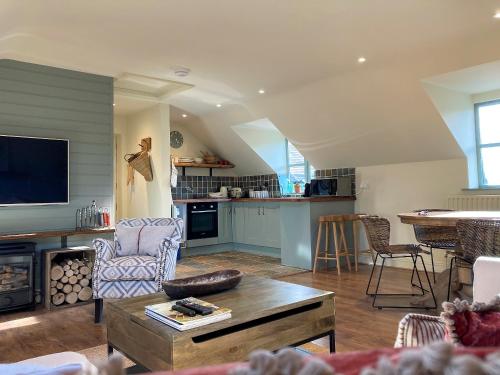 a living room with a couch and a table at Larkhams Loft in Teffont Magna