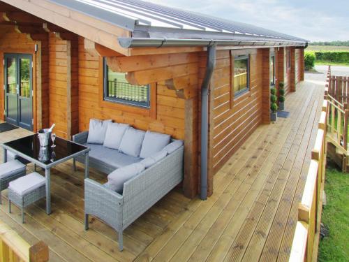 a deck with a couch and a table on a house at Stag Lodge - Uk46921 in Falkirk