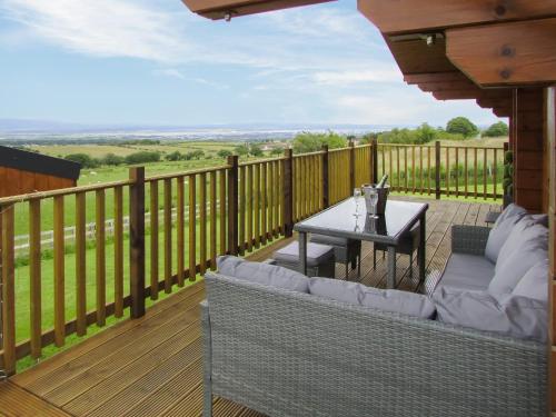 a patio with a table and chairs on a deck at Stag Lodge - Uk46921 in Falkirk