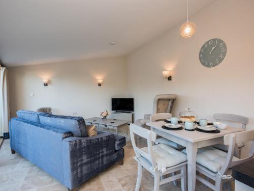 a living room with a blue couch and a table at Woodcrest Barn Cottage - Ukc1065 in Shelfanger