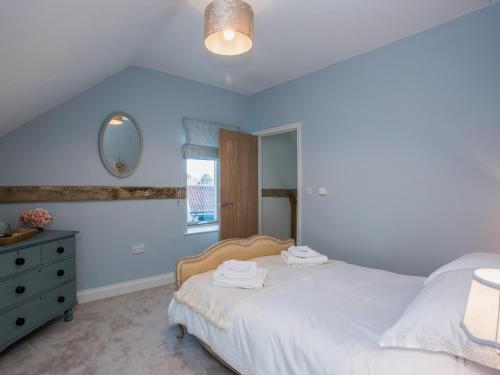 a bedroom with a bed and a dresser and a mirror at Woodcrest Barn Cottage - Ukc1065 in Shelfanger