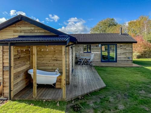 a wooden cabin with a bath tub on a deck at Stillwater in Rockland Saint Peter