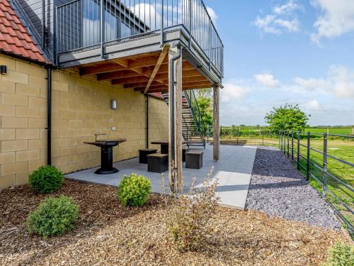 a patio with a wooden pergola and a table at Home Farm Lodges in Baston