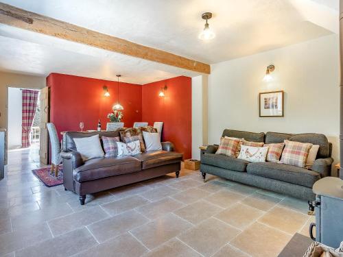 a living room with two couches and a red wall at Queens Barn in Wortham