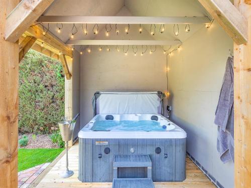 a soak in a hot tub in a shed with lights at Queens Barn in Wortham