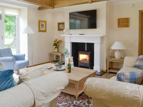 a living room with a couch and a fireplace at The Stables - Uk11108 in Montrose