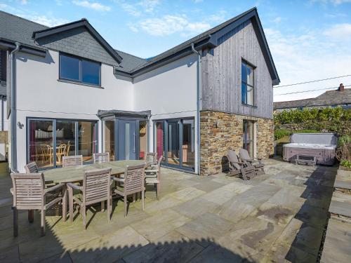 a patio with a wooden table and chairs at Gwithian House in Port Isaac