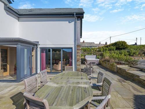 a wooden table and chairs on a patio at Gwithian House in Port Isaac