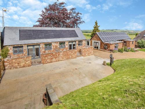 an aerial view of a house with solar panels on the roof at The Old Stables 2 - Uk46683 in Shipton under Wychwood