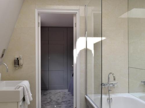 a bathroom with a shower and a tub and a sink at The House At One Warwick Park in Royal Tunbridge Wells