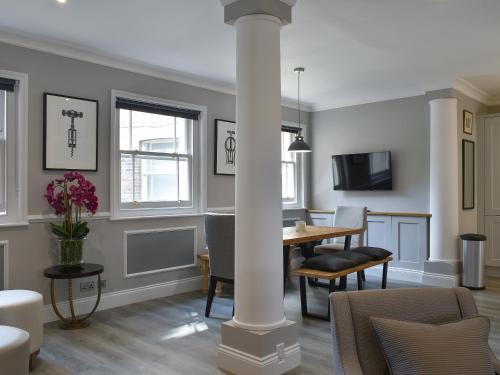 a living room with a column and a table and chairs at The House At One Warwick Park in Royal Tunbridge Wells