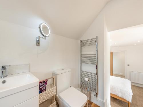 a white bathroom with a sink and a mirror at Beachey View - Uk43058 in Saundersfoot