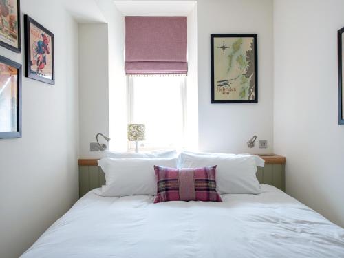 a bedroom with a bed with white pillows and a window at But N' Ben - Uk7560 in Inverness