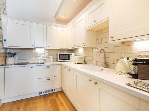a white kitchen with white cabinets and white appliances at But N' Ben - Uk7560 in Inverness
