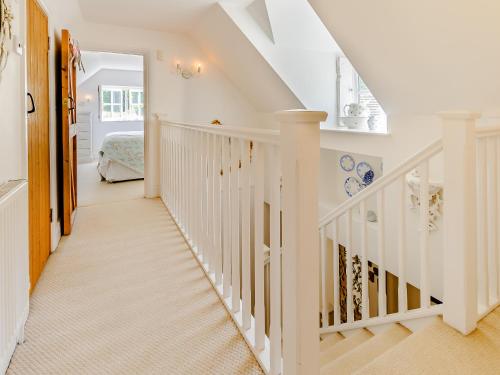 a white staircase in a home with white walls at Poppy's Cottage in Faversham