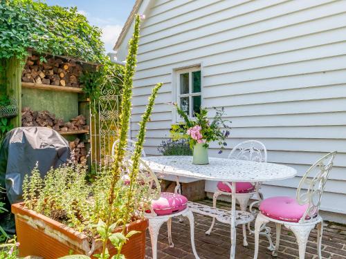a patio with a table and chairs in front of a house at Poppy's Cottage in Faversham