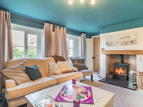 a living room with a couch and a fireplace at Horseshoes House in Watton