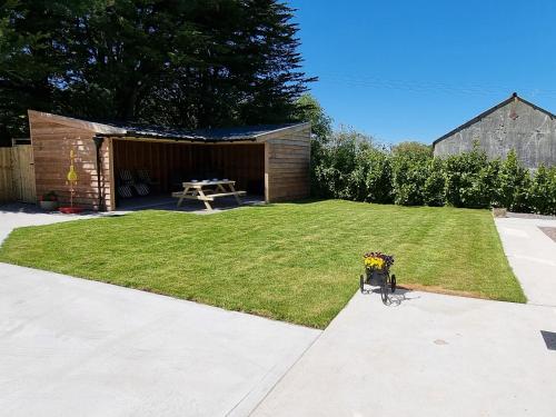 a yard with a picnic shelter and a table with flowers at Dronefield Lodge in Pitney