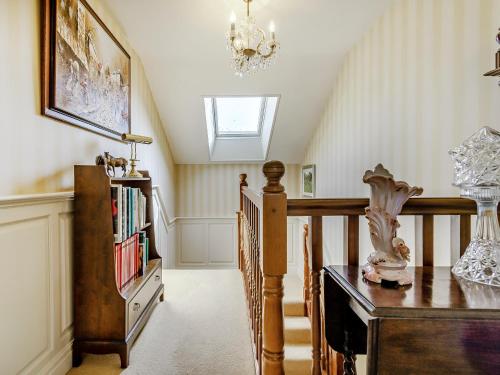 a room with a staircase with a table and a chandelier at The Hawthorns in Ottringham