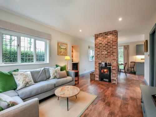 a living room with a couch and a fireplace at Keeds Cottage in Pulborough