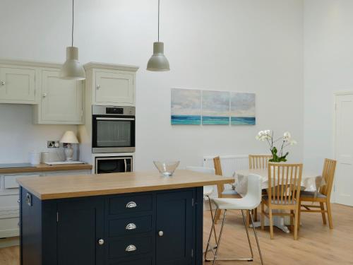 a kitchen with a black island with a wooden counter top at Yonderton Mcgill Cottage - Uk11182 in Hollybush