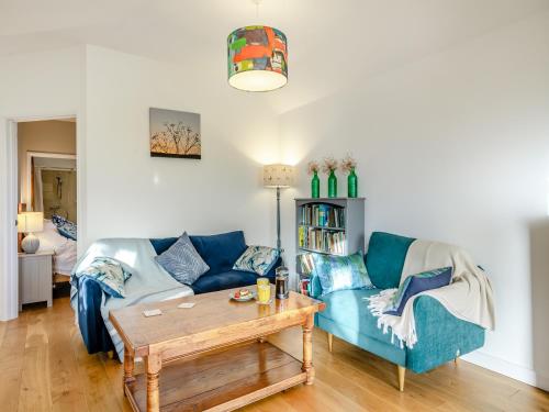 a living room with a blue couch and a table at Larks Nest in Wortham