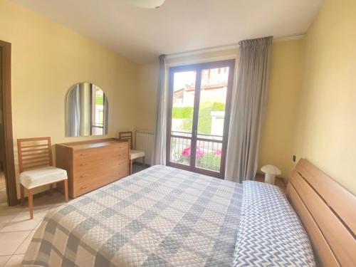 a bedroom with a bed and a window and a dresser at VerdeLago casa vacanze in Luino