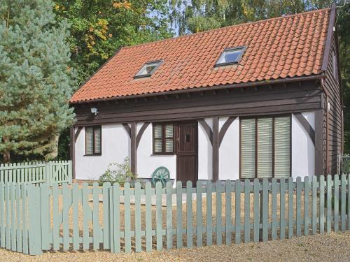 a small house with a fence in front of it at Forest Cottage in Northwold
