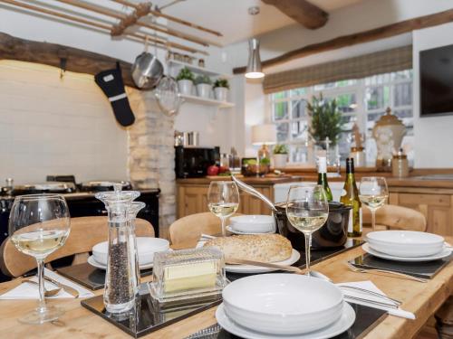 a table with glasses and plates on it in a kitchen at Narrowgates Cottage in Barrowford