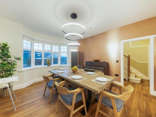 a dining room with a wooden table and chairs at Bryndedwydd in Borth