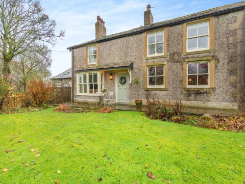 a brick house with a lawn in front of it at Adair Cottage in Wigglesworth