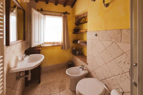 a bathroom with a sink and a toilet and a window at Bea Villa Bea in Caldarola