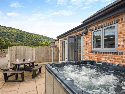 a hot tub on the patio of a house at Ty Felin - Uk12744 in Acrefair