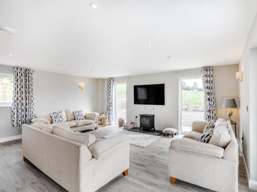 a living room with two couches and a tv at Upper Bryn Y Groes in New Bridge