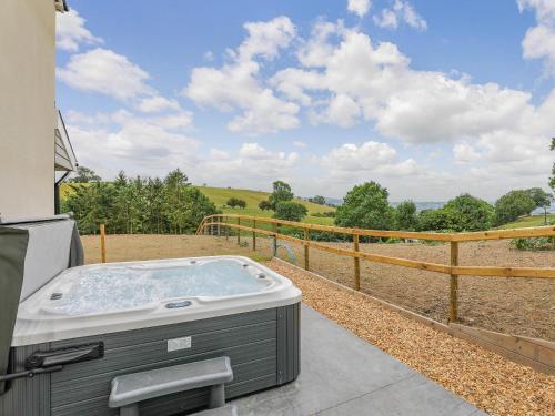 a hot tub on the side of a house at Upper Bryn Y Groes in New Bridge