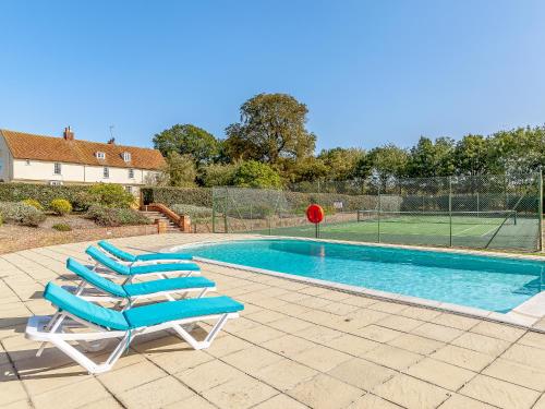 a couple of lounge chairs next to a swimming pool at Pattiswick Hall in Stisted